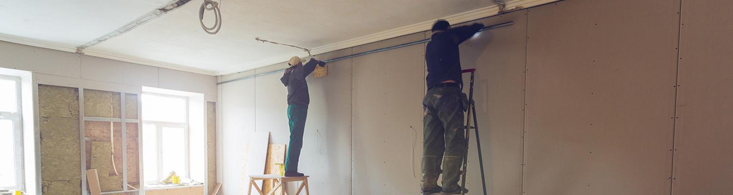 Workers putting in drywall in an office