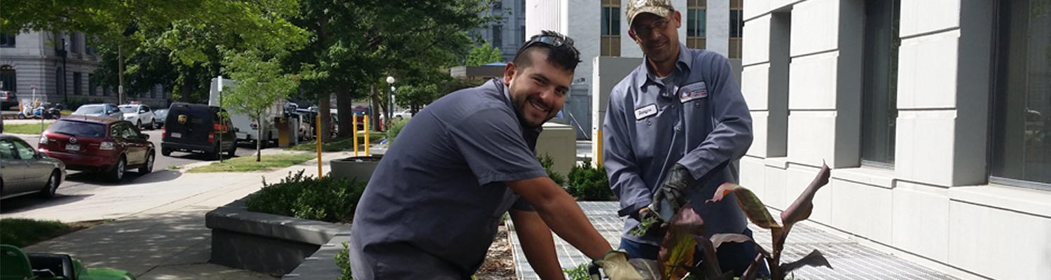 Photo of Capitol Complex Grounds Employees Planting New Plants in outside large planters.