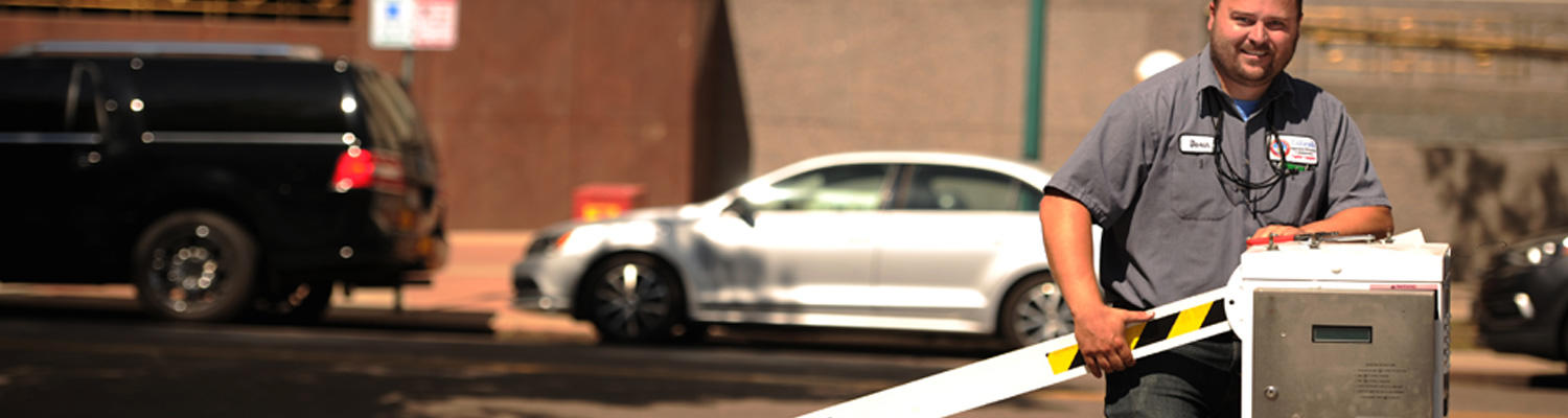 Photo of a Capitol Complex uniformed employee holding the arm of a parking gate to be fixed.