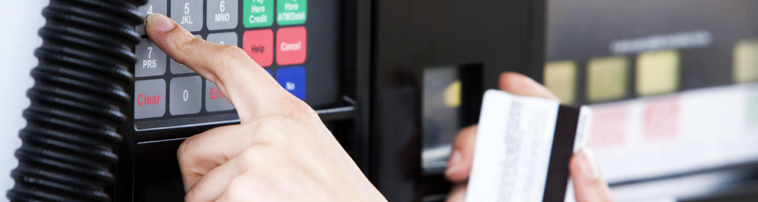 Person at a gas pump punching in numbers