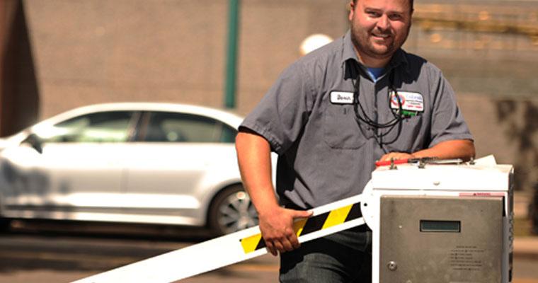 A photo showing worker fixing a parking gate.